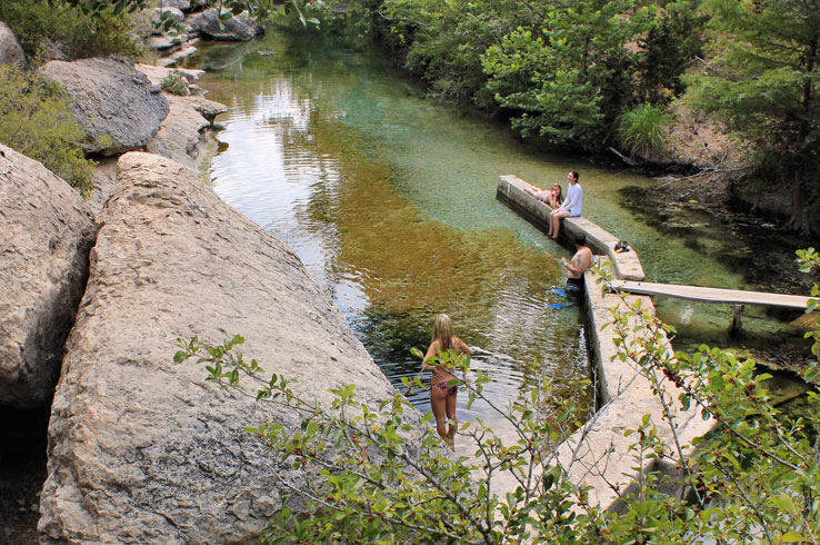 A girl prepares to dive into the crystal clear waters at Jacob's Well.