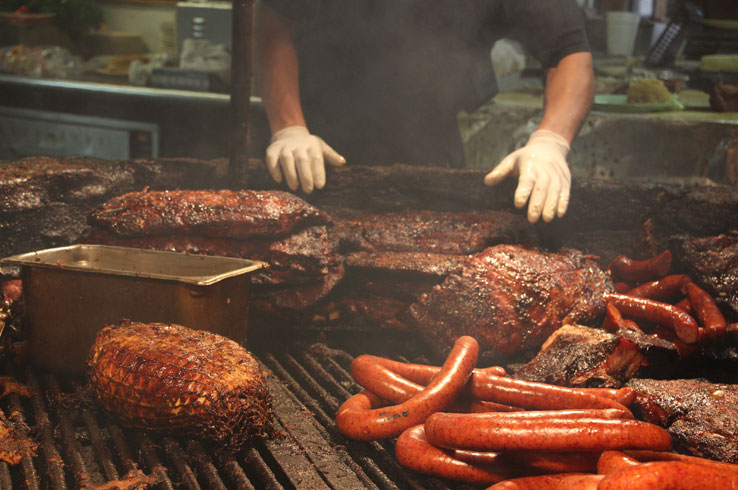 A cook tends to a variety of roasting meat at The Salt Lick in Driftwood, Texas.