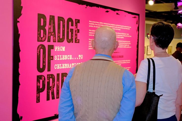 Old couple looks at the Badge of Pride exhibit
