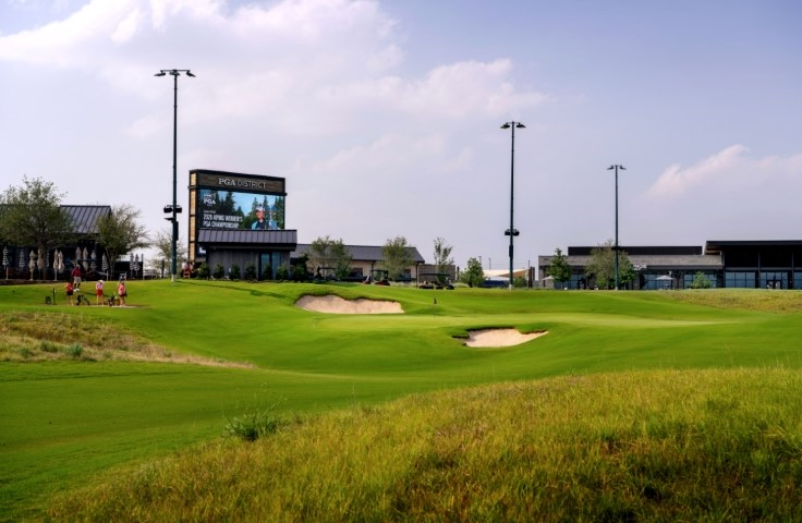 An aerial view of Omni PGA Frisco Resort in Frisco, Texas, showcasing championship golf courses, winding waterways, and expansive resort facilities surrounded by lush green landscapes.