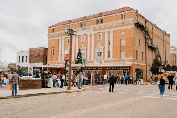 Historic downtown Texarkana with the Perot Theatre in the background and holiday crowds gathering outside on a winter afternoon